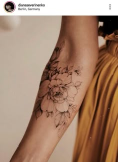 a woman's arm with a flower tattoo on the left side of her arm