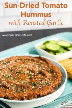 sun dried tomato hummus with roasted garlic in a white bowl on a blue tray