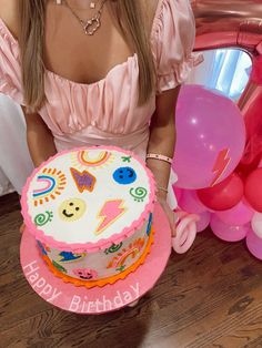 a woman sitting in front of a birthday cake