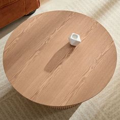 a wooden table with a white object on it in the middle of a living room