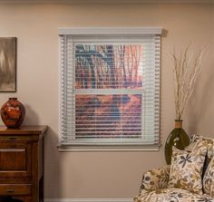 a living room filled with furniture and a painting on the wall next to a window