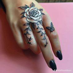 a woman's hand with a rose tattoo on it