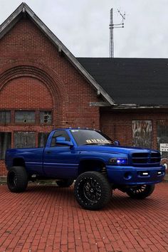 a blue truck parked in front of a brick building