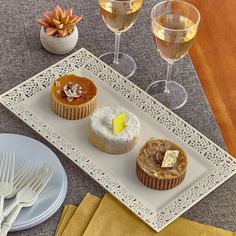 three desserts and wine glasses on a table