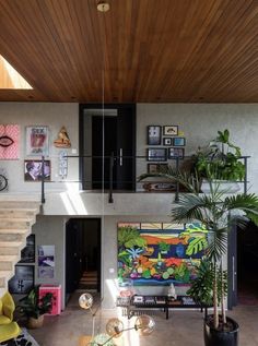 a living room filled with lots of furniture next to a wooden ceiling covered in paintings