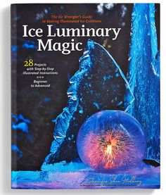 the book ice luminous magic is on display in front of a blue rock and water fountain