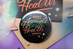 the vegan for animals and health badge is laying on top of some other items