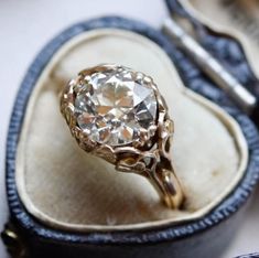 an antique diamond ring sits in its case