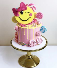 there is a cake that looks like a smiley face on top of it, with sprinkles and lollipops around the edges