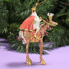 a christmas ornament with a horse wearing a red dress and gold tiara