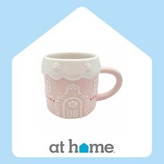 a pink coffee mug with white designs on the outside and inside, sitting in front of a blue background