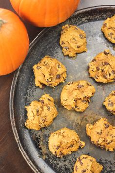 chocolate chip cookies on a baking sheet with pumpkins in the background