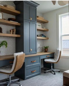 a home office with built in shelving and desk area, along with two chairs