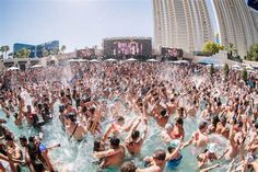 a large group of people are in the water at an outdoor pool and having fun