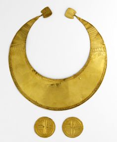 a gold necklace with two pieces of jewelry attached to the neck, on a white background