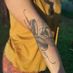 a woman with a bee tattoo on her arm