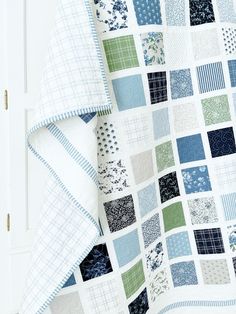 a blue and green patchwork quilt on a white door