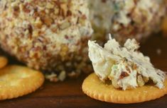 some crackers are laying on a table next to a cheese ball and other snacks