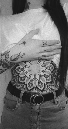 a woman with tattoos on her arms and chest is holding onto the back of her shirt