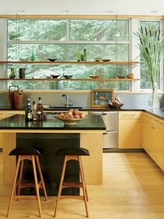 the kitchen is clean and ready to be used for cooking or eating, with two bar stools in front of the island