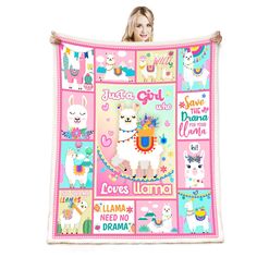 a woman holding up a pink blanket with llamas and unicorns on it