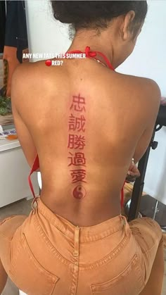 the back of a woman's body with chinese writing on her upper and lower back