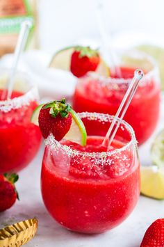 two glasses filled with strawberry margaritas and garnished with strawberries