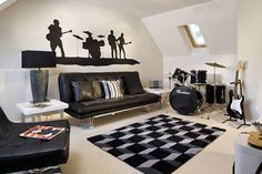 a living room filled with black furniture and musical instruments on the wall next to a checkered rug