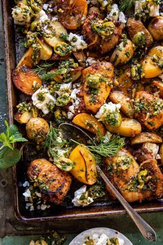 a pan filled with chicken and potatoes covered in herbs