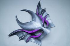 a silver mask with purple accents on it