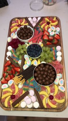 a platter filled with fruit and chocolates on top of a table