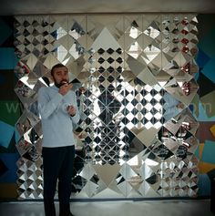 a man standing in front of a mirrored wall