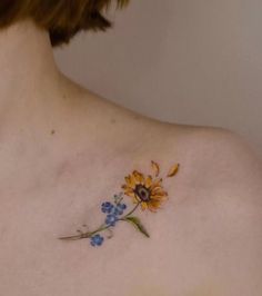 a sunflower tattoo on the back of a woman's shoulder