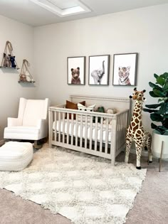 a baby's room with a giraffe, chair and pictures on the wall