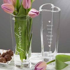 two vases filled with flowers and chocolates on a marble counter top next to each other