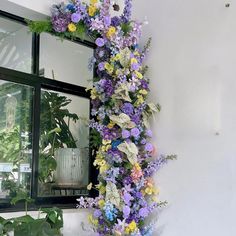 a wall covered in flowers next to a window