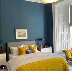 a bedroom with blue walls and yellow accents