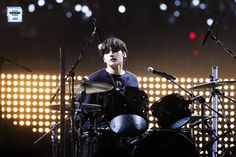 a young man is playing drums on stage