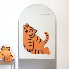 an orange and black tiger sitting on top of a white shelf