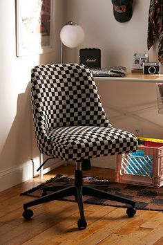 a black and white checkered office chair sitting on top of a hard wood floor