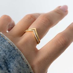 a woman's hand wearing a gold ring with diamonds on the middle and sides