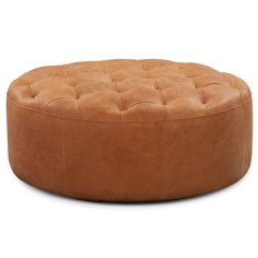 a round leather ottoman sitting on top of a white floor