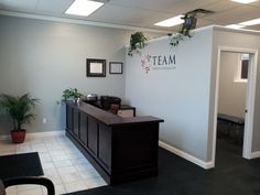 an office with a desk and plant on the wall