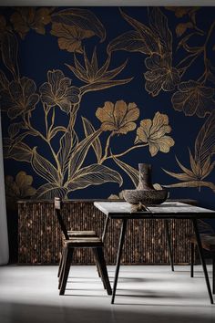 a table with two chairs and a vase on it in front of a floral wallpaper