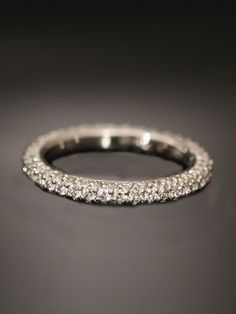 a diamond wedding band on a black surface