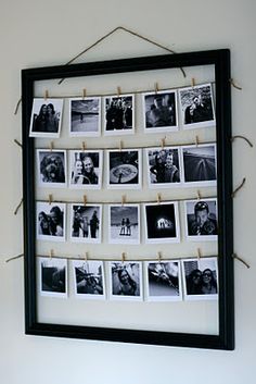 a black and white photo hanging on a wall with clothes pins in front of it