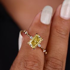 a woman's hand with a yellow diamond ring