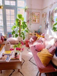 a living room filled with lots of furniture and plants