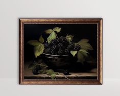 a painting of blackberries in a bowl with green leaves on the table next to it