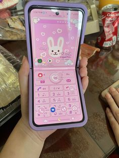 a person holding up a pink cell phone with an animal design on the front and side